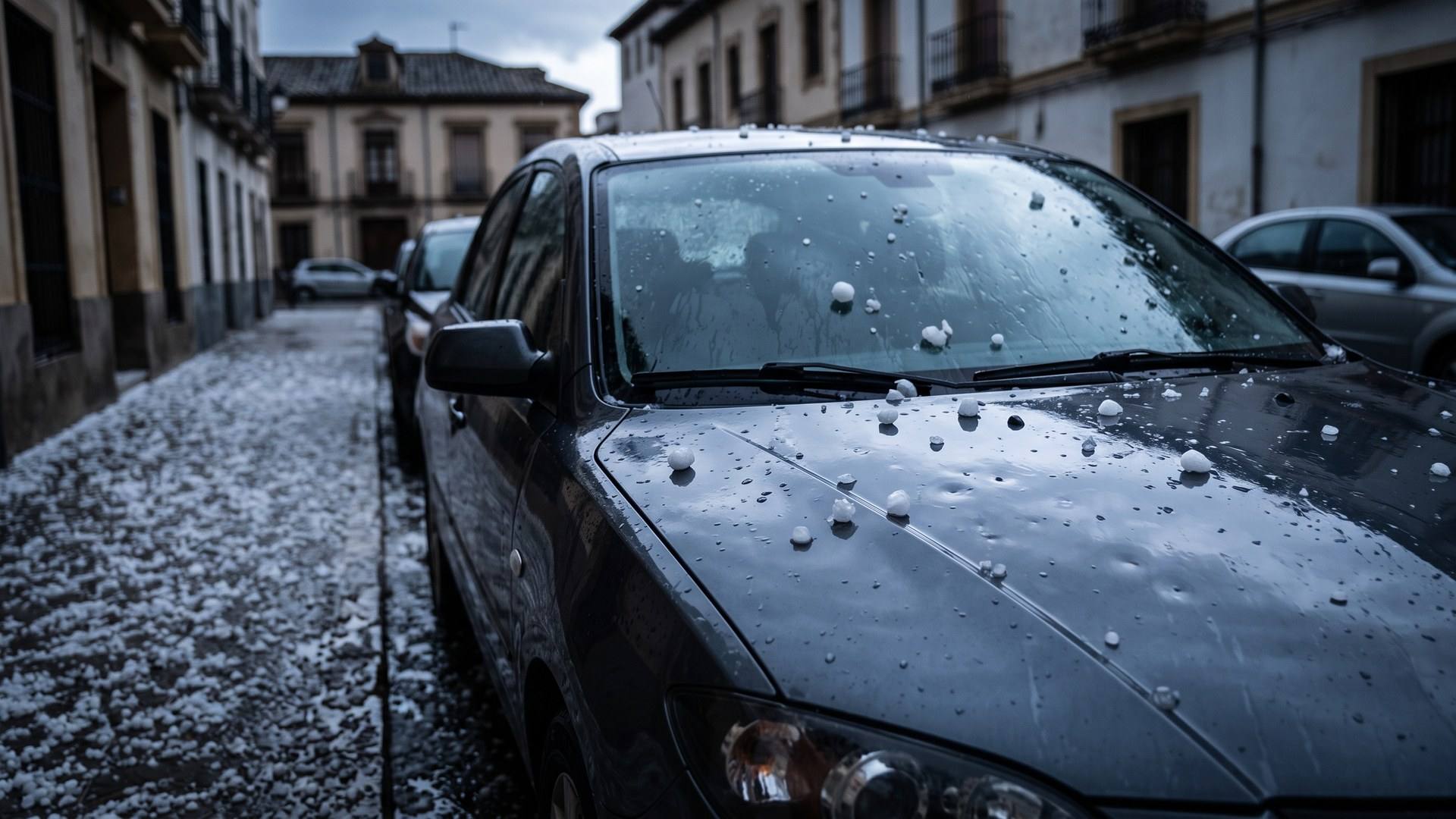 Coche aparcado en la calle cubierto de granizo en Zaragoza